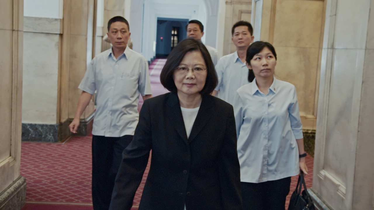 a woman in a blazer leading a group of people